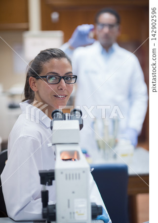 Middle Eastern medical team in laboratory performing blood testing and microscopy with focused researchers Middle Eastern medical team in laboratory performing blood testing and microscopy with focused researchers 142902596