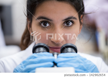 Young female doctor in laboratory using microscope for blood testing and clinical research Young female doctor in laboratory using microscope for blood testing and clinical research 142902654