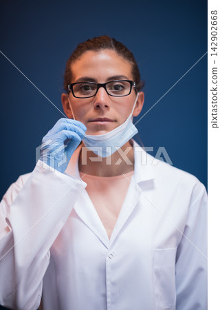 Female doctor and lab technician wearing mask and gloves preparing for blood testing in laboratory Female doctor and lab technician wearing mask and gloves preparing for blood testing in laboratory 142902668
