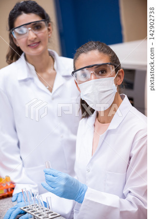 Middle Eastern female doctors and medical technician performing blood testing in a clinical laboratory wearing PPE Middle Eastern female doctors and medical technician performing blood testing in a clinical laboratory wearing PPE 142902738