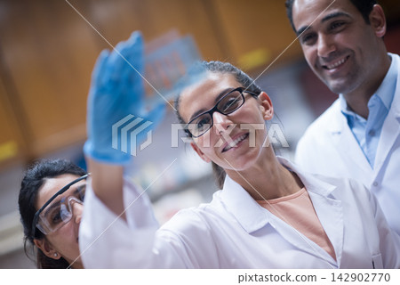 Young doctors and medical technician collaborating in a clinical laboratory during blood testing and research Young doctors and medical technician collaborating in a clinical laboratory during blood testing and research 142902770