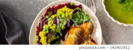 Baked small sea fish is served alongside boiled beets, hummus, green peas, and herbs. This dish is suitable for breakfast and offers a healthy option, banner Baked small sea fish is served alongside boiled beets, hummus, green peas, and herbs. This dish is suitable for breakfast and offers a healthy option, banner 142902912
