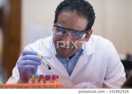 Middle Eastern doctor and lab technician smiling while examining a blood sample in a clinical laboratory Middle Eastern doctor and lab technician smiling while examining a blood sample in a clinical laboratory 142902926