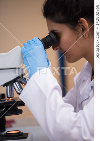 Middle Eastern young doctor examining a microscope while working in a blood testing laboratory Middle Eastern young doctor examining a microscope while working in a blood testing laboratory 142902959