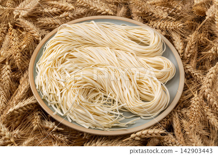 fresh Handmade Raw Wheat Noodles Resting on Wooden Surface fresh Handmade Raw Wheat Noodles Resting on Wooden Surface 142903443