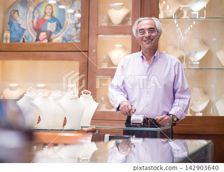 Middle Eastern couple shopping for a wedding ring with friendly jeweler and family in a jewelry store Middle Eastern couple shopping for a wedding ring with friendly jeweler and family in a jewelry store 142903640