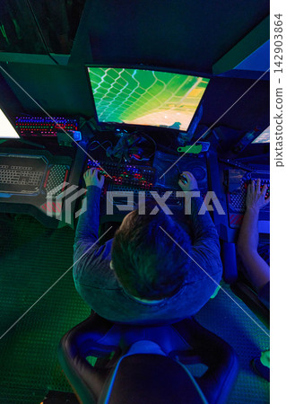 Top View Of Focused Gamer Playing On PC With RGB Keyboard In Neon Esports Setup Top View Of Focused Gamer Playing On PC With RGB Keyboard In Neon Esports Setup 142903864