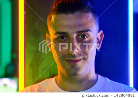 Young Man Portrait With Neon Lighting Smiling In Urban Nightclub Atmosphere 142904081