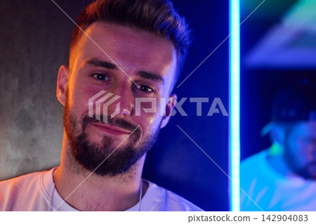Smiling Young Man Portrait With Beard in Neon Light Casual Urban Nightlife Vibe Smiling Young Man Portrait With Beard in Neon Light Casual Urban Nightlife Vibe 142904083