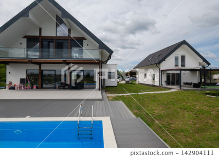 Modern family home with pool, patio and balcony overlooking a spacious suburban backyard Modern family home with pool, patio and balcony overlooking a spacious suburban backyard 142904111