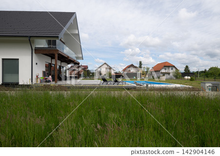 Modern suburban house with swimming pool and spacious backyard patio Modern suburban house with swimming pool and spacious backyard patio 142904146