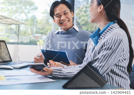 Business professional analyzing financial data on digital tablet dashboard with calculator and laptop, representing accounting software, ERP system integration, performance monitoring. 142904481