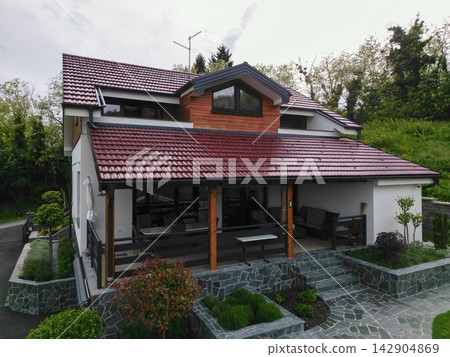 Modern two-story house with covered patio, red tile roof and landscaped stone terrace Modern two-story house with covered patio, red tile roof and landscaped stone terrace 142904869