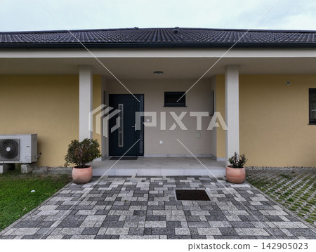 Modular modern house entrance with minimalist facade, low-energy design and high-efficiency heating, cooling and solar panels Modular modern house entrance with minimalist facade, low-energy design and high-efficiency heating, cooling and solar panels 142905023
