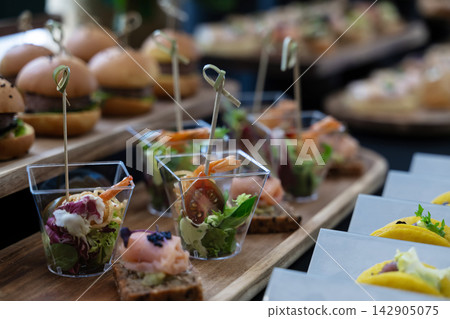 Elegant shrimp appetizers in clear cups served at a catered party or wedding reception buffet Elegant shrimp appetizers in clear cups served at a catered party or wedding reception buffet 142905075