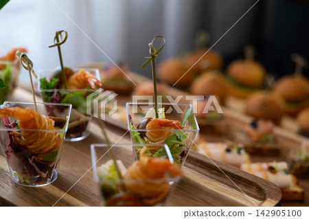 Elegant shrimp appetizers in clear cups served at a catered party or wedding reception buffet 142905100