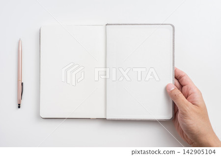 Top view of open blank notebook mockup with hand holding page on white background 142905104