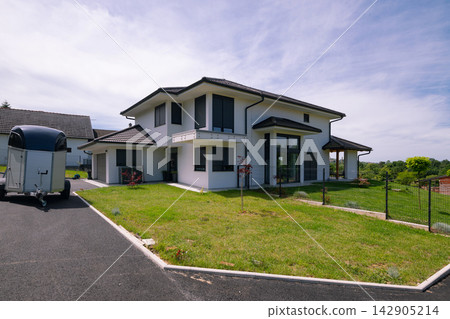 Modern modular minimalist house with energy efficient design and solar panels in a suburban setting Modern modular minimalist house with energy efficient design and solar panels in a suburban setting 142905214