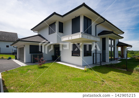 Modern modular energy-efficient house with minimalist design and solar panels in a suburban setting 142905215