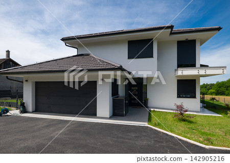 Modern modular minimalist two-story house with double garage, solar panels and energy-efficient design Modern modular minimalist two-story house with double garage, solar panels and energy-efficient design 142905216