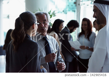 Business professionals networking and discussing in a corporate lobby during a casual meeting Business professionals networking and discussing in a corporate lobby during a casual meeting 142905416
