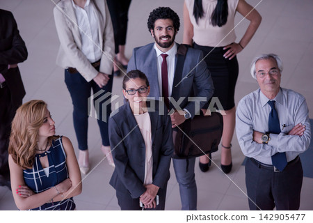 Business team of diverse professionals standing together in an office looking confident and approachable Business team of diverse professionals standing together in an office looking confident and approachable 142905477
