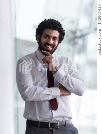 Smiling businessman portrait in office wearing white shirt and red tie, confident professional expression Smiling businessman portrait in office wearing white shirt and red tie, confident professional expression 142905489