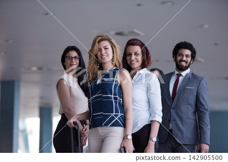 Confident diverse business team of young professionals standing in modern office lobby smiling Confident diverse business team of young professionals standing in modern office lobby smiling 142905500