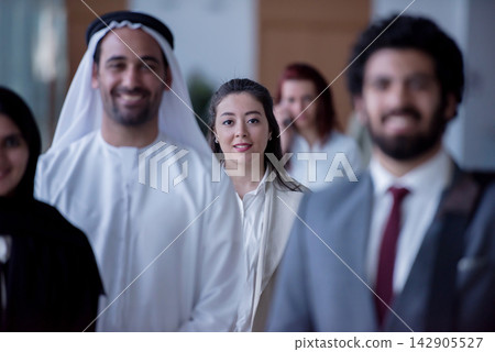 Young professional woman among diverse business team in modern office corridor, confident and focused 142905527