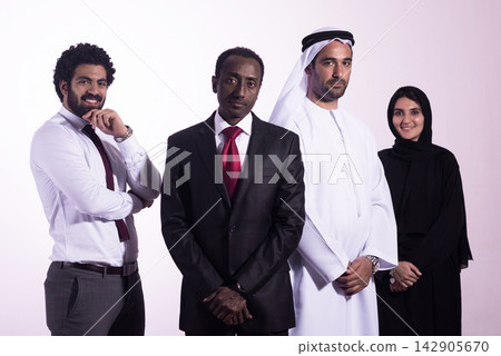 Diverse professional team in business suits and traditional Middle Eastern dress posing confidently Diverse professional team in business suits and traditional Middle Eastern dress posing confidently 142905670