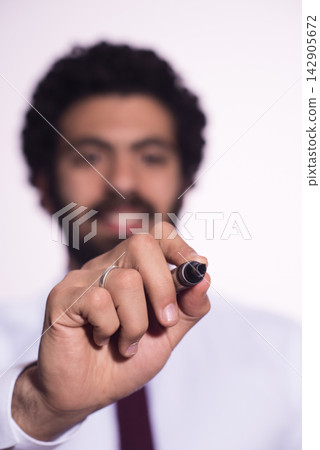 Businessman writing with marker toward camera during presentation and brainstorming session Businessman writing with marker toward camera during presentation and brainstorming session 142905672