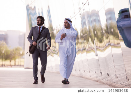 Business colleagues walking and talking outside a modern office building in Middle East city 142905688