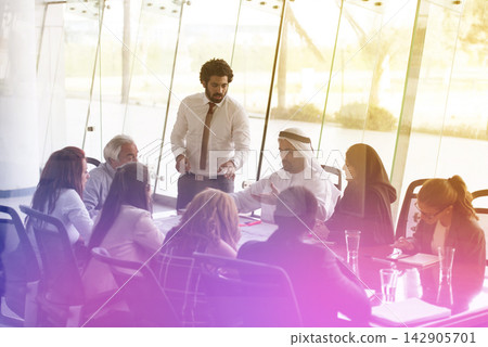 Middle Eastern business team in a modern corporate meeting with a smiling presenter leading discussion Middle Eastern business team in a modern corporate meeting with a smiling presenter leading discussion 142905701