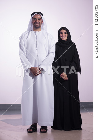 Emirati couple in traditional clothing smiling together in a studio portrait showing cultural pride and unity Emirati couple in traditional clothing smiling together in a studio portrait showing cultural pride and unity 142905705