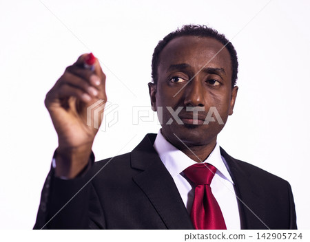 Businessman in suit and red tie writing on an invisible board during a presentation and planning session Businessman in suit and red tie writing on an invisible board during a presentation and planning session 142905724