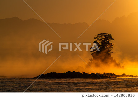 從富山縣的雨晴海岸望去,日出時分,金色的陽光灑滿大海。 從富山縣的雨晴海岸望去,日出時分,金色的陽光灑滿大海。 142905936