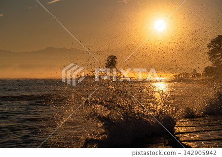 The sunrise and the sea bathed in golden hues at dawn, as seen from Amaharashi Coast in Toyama. The sunrise and the sea bathed in golden hues at dawn, as seen from Amaharashi Coast in Toyama. 142905942