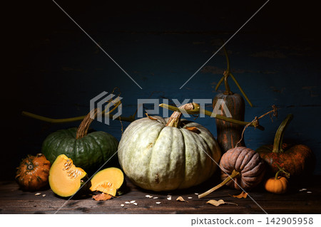 Pumpkins with sliced squash arranged on wooden surface Pumpkins with sliced squash arranged on wooden surface 142905958