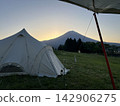 A grassy campsite with a view of Mt. Fuji before sunrise. 142906275