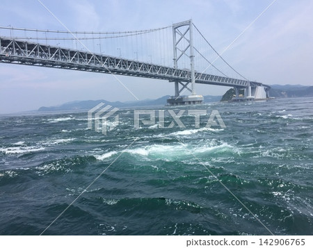 The strong currents of the Naruto Strait flow beneath the Great Naruto Bridge The strong currents of the Naruto Strait flow beneath the Great Naruto Bridge 142906765