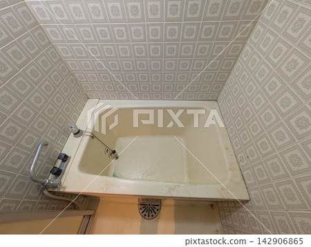An old bathtub and retro tiled bathroom in an old house 142906865