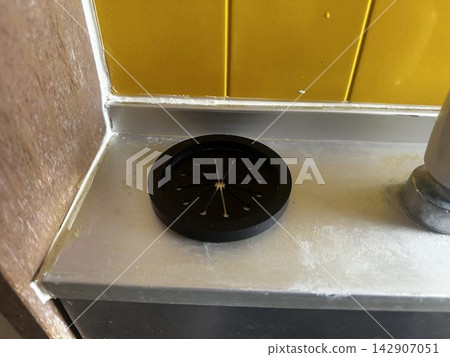 廚房水槽裡放著一個黑色的排水蓋。 142907051