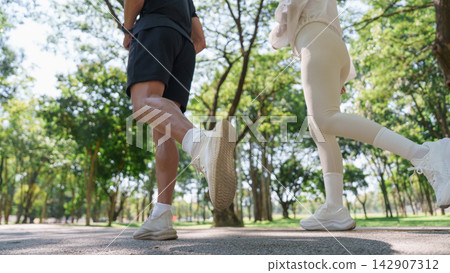 Cropped view of active couple jogging together in park for outdoor workout 142907312
