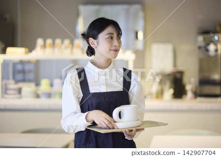 Female staff serving coffee at the cafe Female staff serving coffee at the cafe 142907704