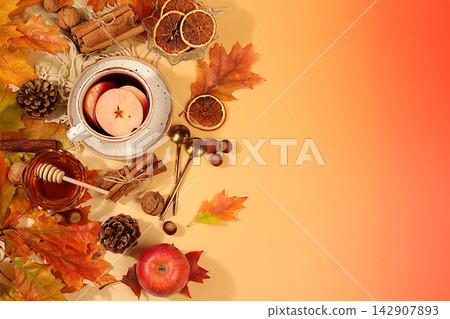 Bright autumn banner with cup of tea or mulled wine, maple leaves, pine cones, nuts, cinnamon, star anise and dried oranges, abstract seasonal composition and still life, Thanksgiving concept Bright autumn banner with cup of tea or mulled wine, maple leaves, pine cones, nuts, cinnamon, star anise and dried oranges, abstract seasonal composition and still life, Thanksgiving concept 142907893