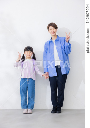 一位活潑的小學生和她的母親 一位活潑的小學生和她的母親 142907994