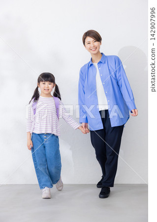 一位活潑的小學生和她的母親 一位活潑的小學生和她的母親 142907996