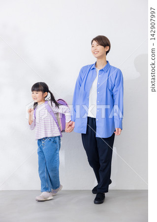 一位活潑的小學生和她的母親 一位活潑的小學生和她的母親 142907997