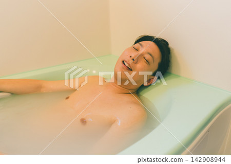 A man in his late 30s relaxing in the bathtub. A man in his late 30s relaxing in the bathtub. 142908944
