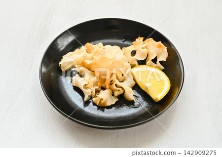 Stir-fried Sparassis crispa mushrooms with soy sauce and butter, served with lemon. Stir-fried Sparassis crispa mushrooms with soy sauce and butter, served with lemon. 142909275